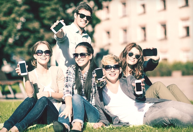 éducation, technologie, internet, vacances d'été, réseaux sociaux et concept d'adolescent - groupe d'adolescents avec smartphones