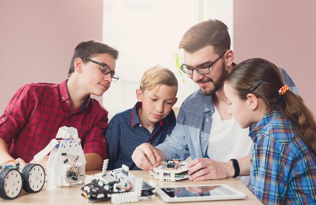 L'éducation des tiges. Ravi de petits scientifiques construisant des robots avec un enseignant. Développement précoce, bricolage, innovation, éducation intégrée, concept de technologie moderne