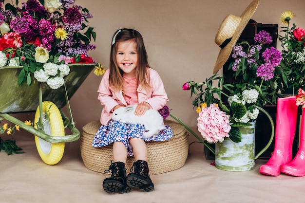 Effet de bruit Jolie fille d'âge préscolaire avec des outils de jardin de fleurs de printemps et des animaux Ambiance de Pâques sur