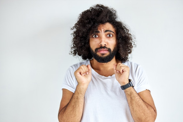 Effrayé Jeune Homme Arabe Bouclé Se Tenir Dans La Peur Par Quelque Chose, Regarder La Caméra