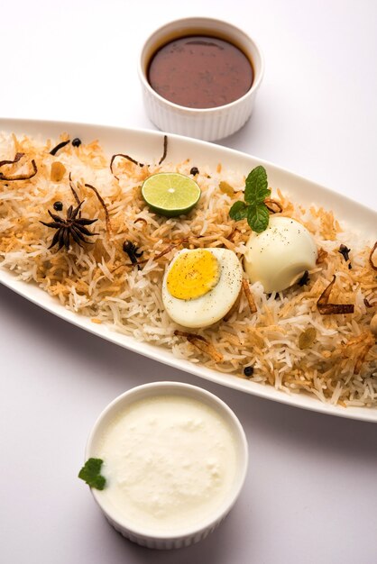 Egg Biryani - Riz basmati cuit avec des œufs rôtis au masala et des épices et servi avec du yaourt, mise au point sélective