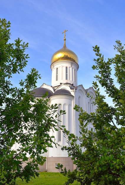 L'église blanche avec un dôme doré dans le style architectural russe est entourée de feuillages d'arbres. Sibérie, Russie