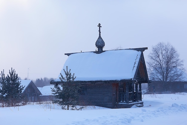 église en bois solitaire sur le terrain / concept foi, dieu, solitude, architecture dans le paysage hivernal