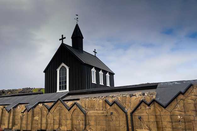 Une église noire avec une croix au sommet