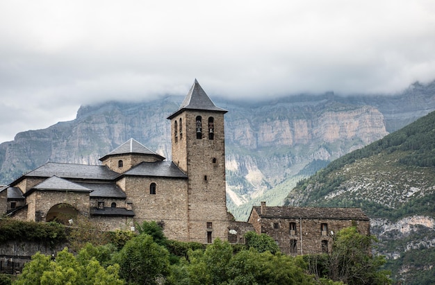 Photo Église de san salvador à torla ordesa avec monte perdido en arrière-plan un jour brumeux pyrénées