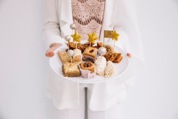 Photo eid concept avec femme tenant une patisserie arabe