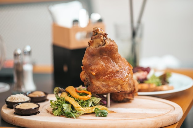 Eisbein de jarret de porc rôti avec salade et moutarde sur une planche à découper en bois