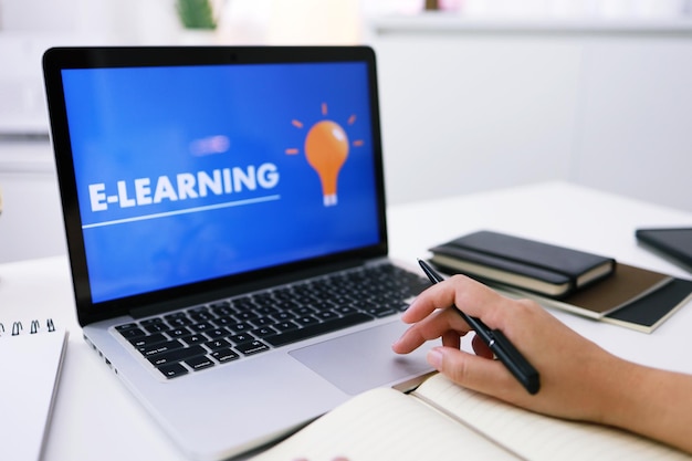 Elearning Education Internet Networking Young businesswoman sitting at table a utilisé un ordinateur portable avec inscription à l'écran