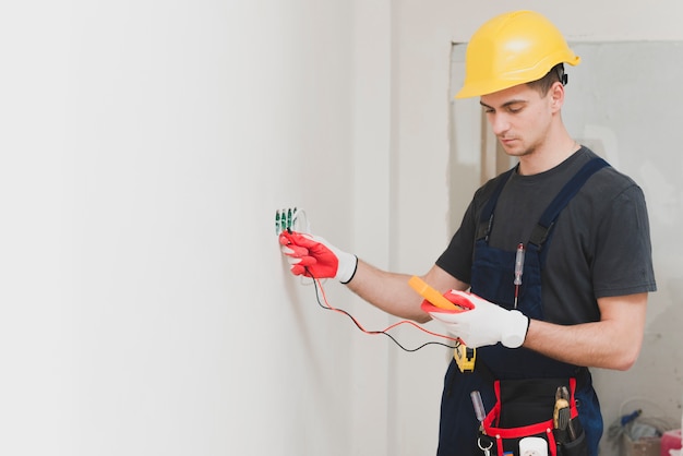 Photo Électricien faisant mesure à la prise