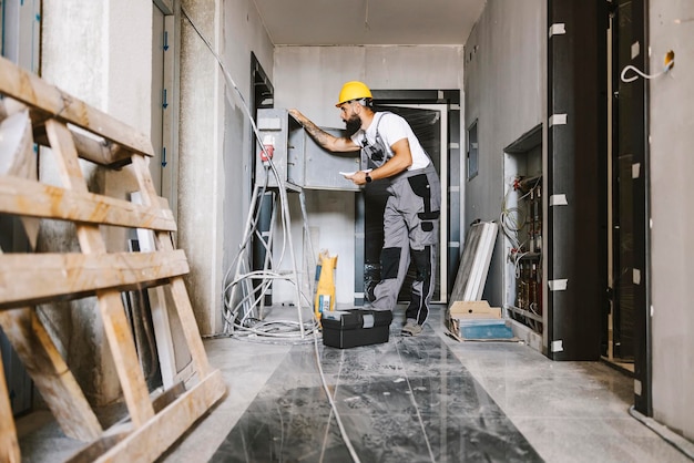 Un électricien fixant l'électricité dans un bâtiment en cours de construction