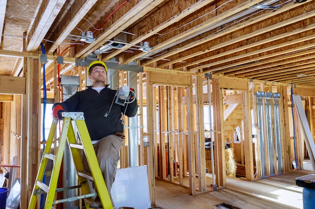 Un électricien installe et monte l'éclairage intérieur au plafond