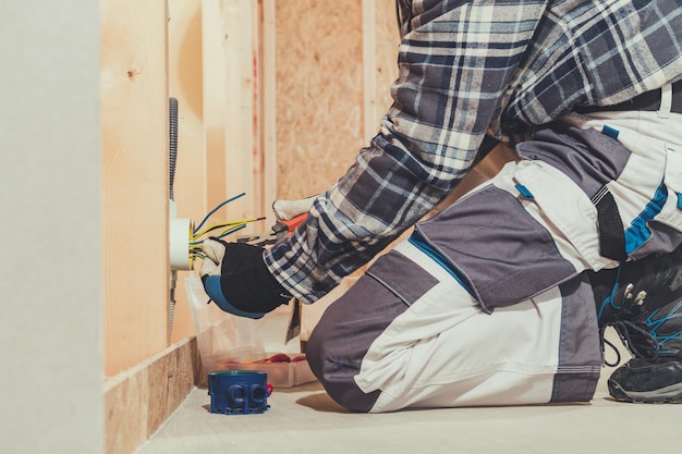 Électricien et son travail lors de l'aménagement d'une maison Installation d'une prise électrique