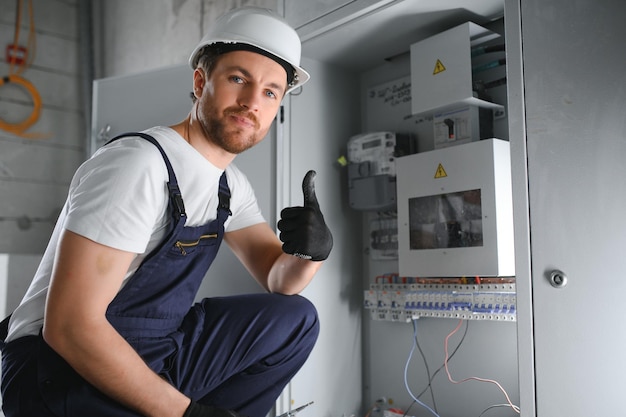 Un électricien travaille dans un central électrique avec un câble de connexion électrique