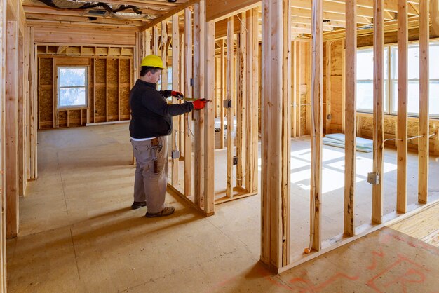 Un électricien vérifiant inspecte les systèmes électriques de la maison, un électricien tient une tablette PC