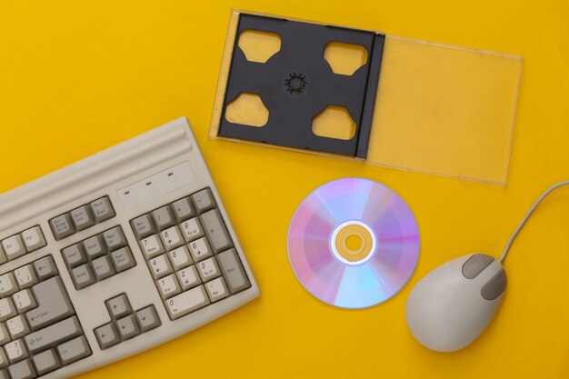 Electronique rétro, technologie pc des années 90. Clavier PC, souris, cd sur fond bleu. Vue de dessus