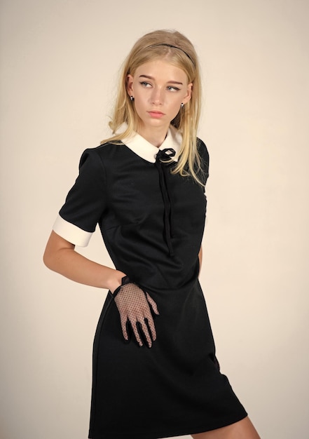 Élégance dans la simplicité Uniforme à la mode Style vintage et rétro Concept de mode vintage Fille blonde porte une robe noire élégante Uniforme formel École d'élite Collège ou femme de ménage Modèle vintage