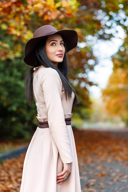 L'élégance urbaine rencontre la beauté naturelle Une femme à la mode avec des yeux brillants regarde vers le haut parmi la beauté de l'automne