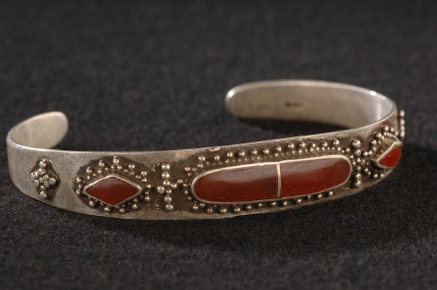 Un élégant bracelet antique avec gravure et pierres précieuses rouges isolé sur fond noir