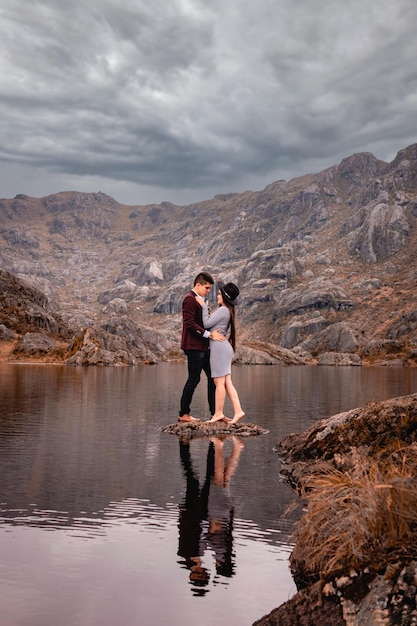 Photo Élégant couple d'amoureux se regardant fixement dans un paysage au bord d'un lac