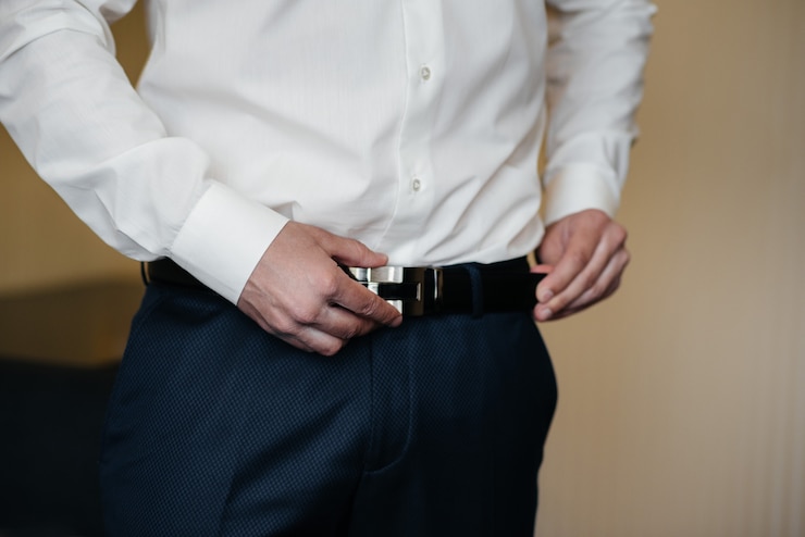 Photo élégant jeune homme boutonnant les boutons de manchette sur les manches. style.