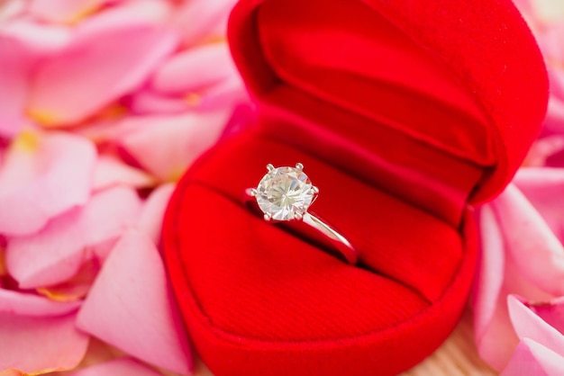 Élégante Bague En Diamant De Mariage Dans Une Boîte à Bijoux Coeur Rouge Sur Fond De Pétale De Rose Rose Magnifique