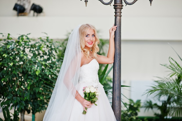 Elégante blonde aux yeux bleus fashion mariée au grand hall de mariage