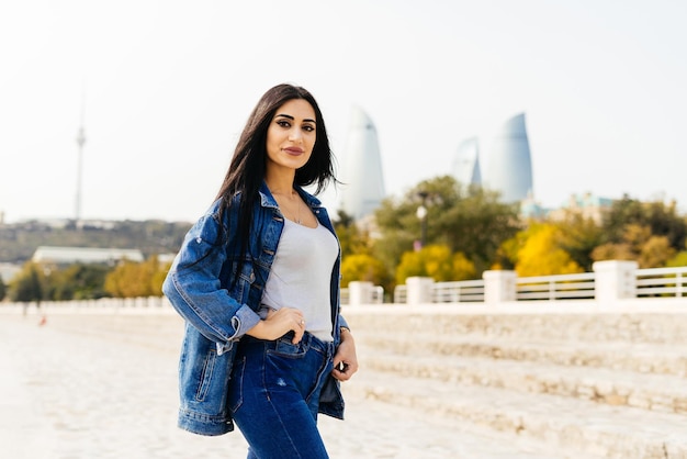 Une élégante fille aux cheveux noirs voyage à travers l'Azerbaïdjan, se promène dans la ville de Bakou
