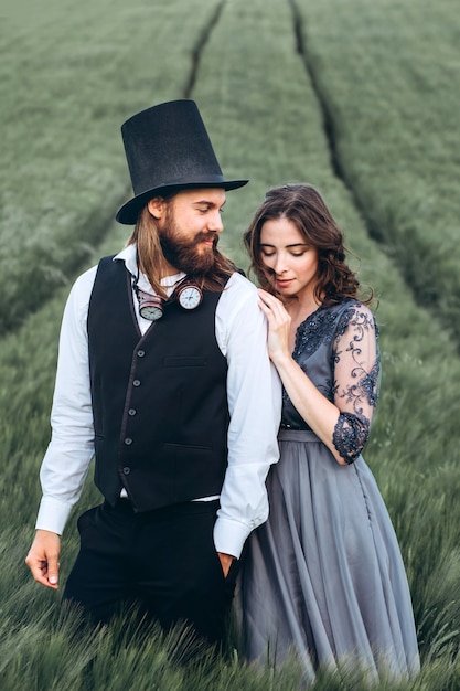 Photo Élégante mariée et le marié marchant et posant sur champ vert