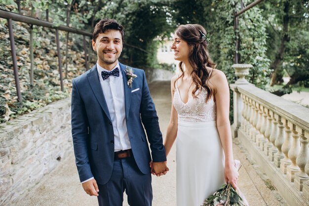 Élégante mariée et le marié posant ensemble à l'extérieur un jour de mariage