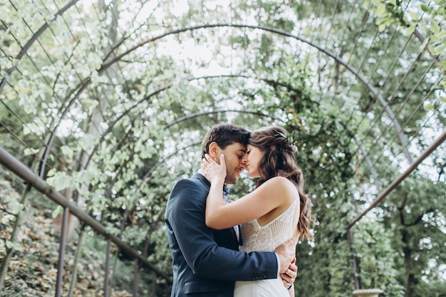 Élégante mariée et le marié posant ensemble à l'extérieur