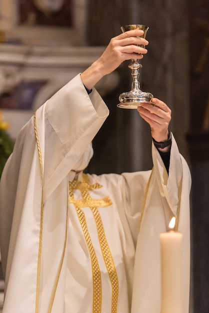 Photo l'élévation de la coupe avec le vin sacramentel pendant la liturgie catholique de l'eucharistie