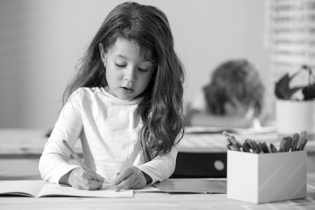 L'élève d'enfant dessine dans la salle de classe à l'école