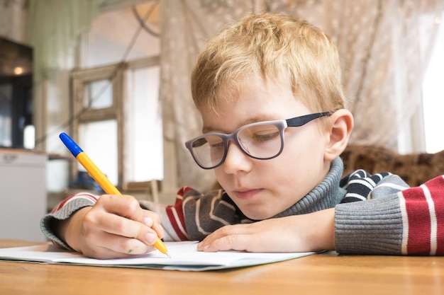 Un élève de première année concentré apprenant à écrire et à faire ses devoirs.