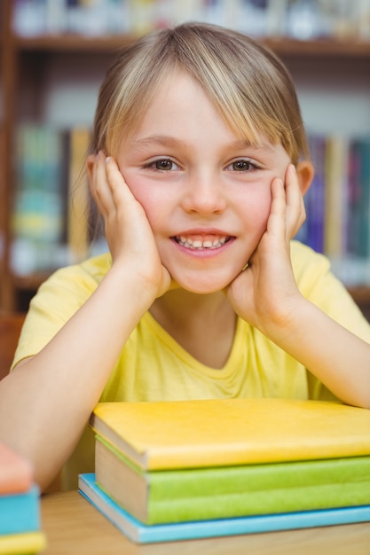 Élève souriant à la caméra dans la bibliothèque