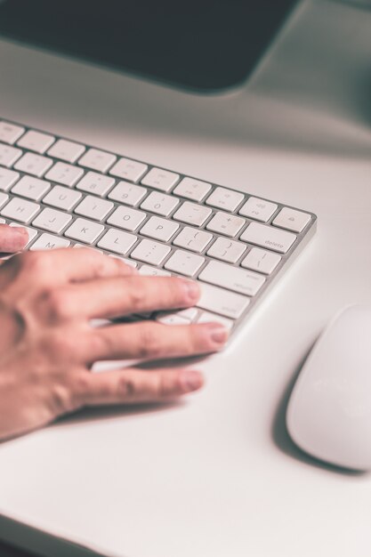 L'élève tape sur le clavier et un bureau blanc.