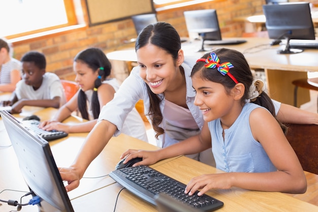 Élèves mignons en cours d&#39;informatique avec professeur