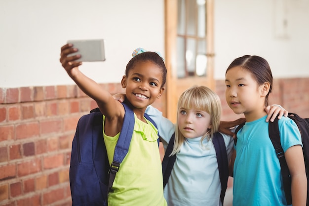 Photo Élèves mignons prenant selfies au couloir