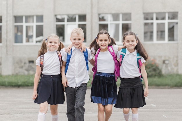 Photo Élèves souriants, serrant près de l'école