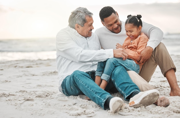 Elle aime la plage. Photo pleine longueur d'une adorable petite fille sur la plage avec son père et son grand-père.