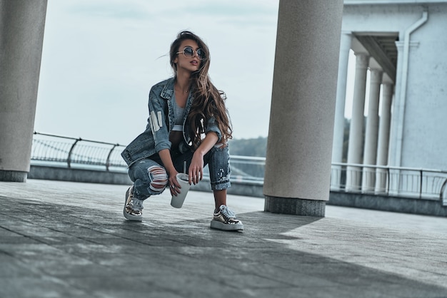 elle est tout au sujet de la mode. belle jeune femme en jeans porter à l'écart