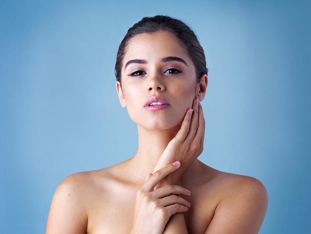 Elle est tout au sujet des soins de la peau Portrait en studio d'une belle jeune femme posant sur un fond bleu