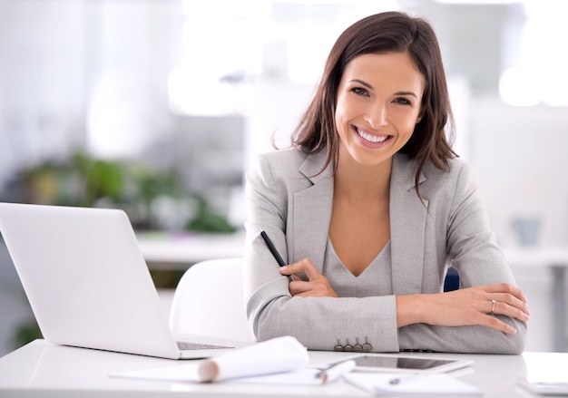 Elle a fait une photo d'une jolie femme d'affaires assise à son bureau dans un bureau