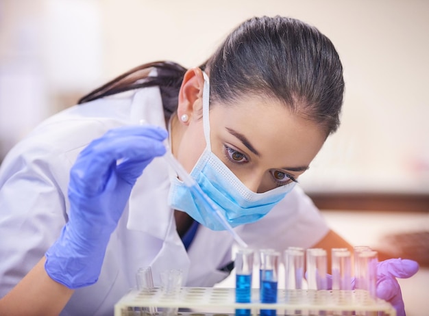 Elle ne s'arrêtera pas jusqu'à ce qu'elle trouve un remède Photo d'un jeune scientifique transférant un liquide d'une pipette à un tube à essai dans un laboratoire