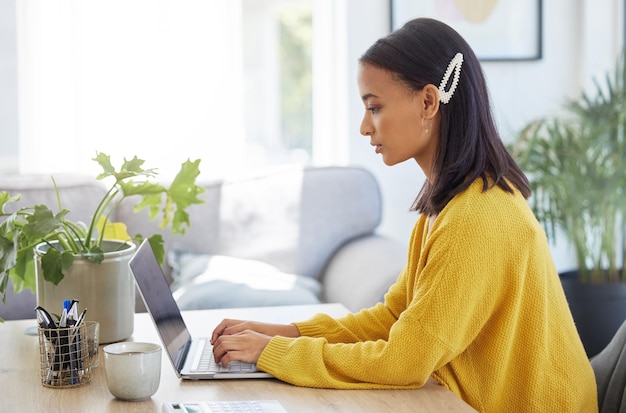 Elle s'est concentrée Photo d'une jeune femme d'affaires utilisant un ordinateur portable dans un bureau moderne au travail