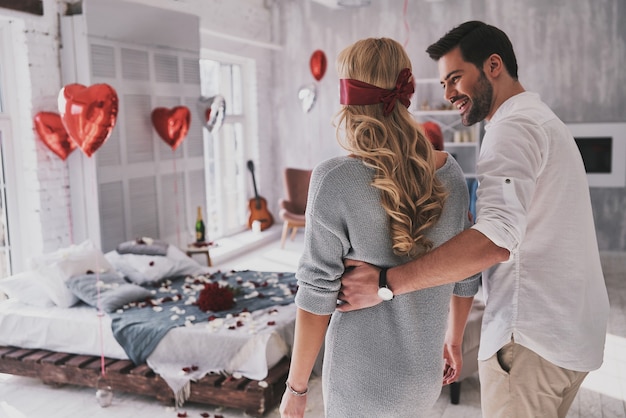 Elle se souviendra de ce jour. Jeune femme marchant les yeux bandés dans la chambre avec son petit ami tout en passant du temps à la maison