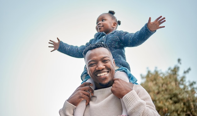 Elle sera toujours ma petite princesse Portrait d'un père portant sa fille sur ses épaules à l'extérieur