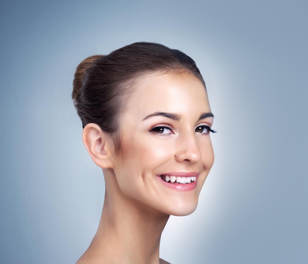 Elle a un sourire qui fait fondre les cœurs Portrait en studio d'une belle jeune mannequin posant sur un fond bleu