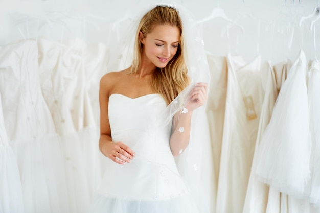 Elle va faire une belle mariée Une jeune mariée essayant sa robe de mariée Copyspace