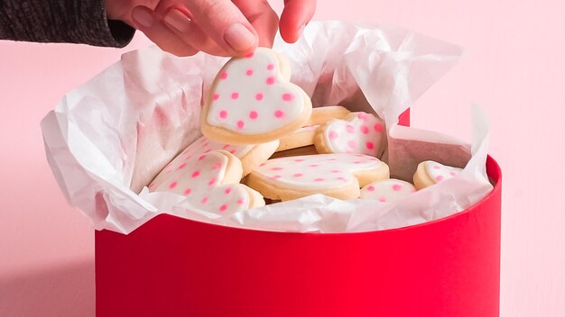 Emballage de biscuits au sucre en forme de cœur décorés de glaçage royal dans la boîte cadeau.