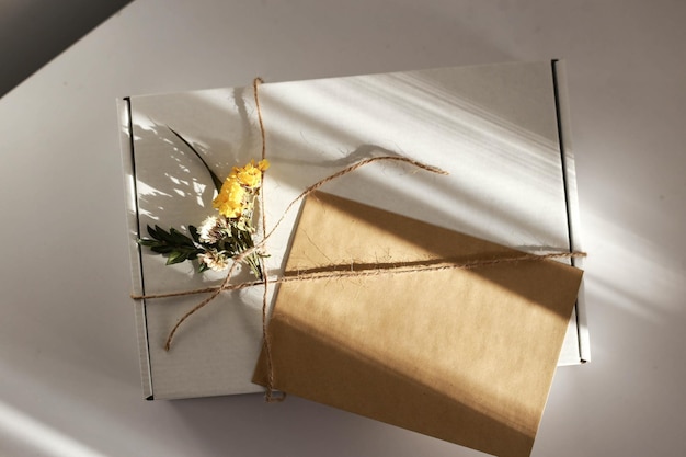 Emballage cadeau avec enveloppe aux couleurs blanc et beige